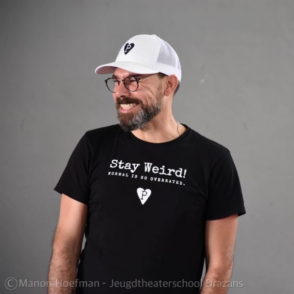 Andy Kirchner wearing the Stay Weird Organic T and white truckers cap